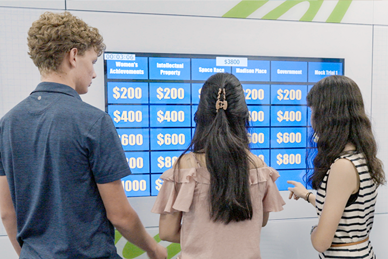 Students using interactive touchscreen to play Jeopardy